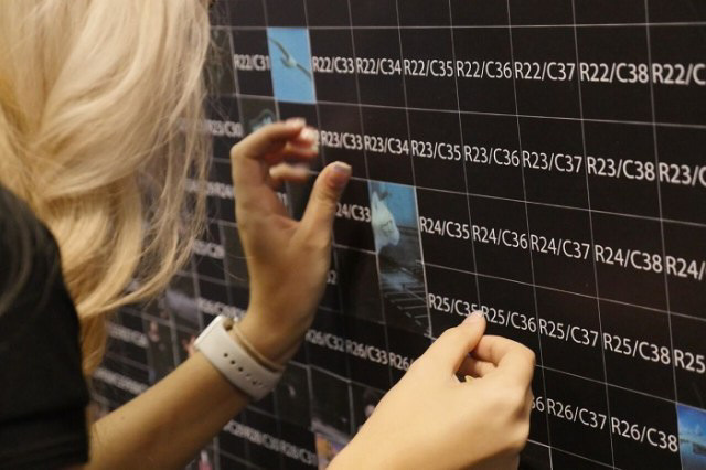 Guests placing photo stickers on the Mosaic Wall